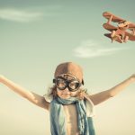 Happy kid playing with toy airplane
